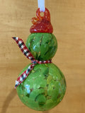 Green Bodied snowman, with red hat and plaid scarf